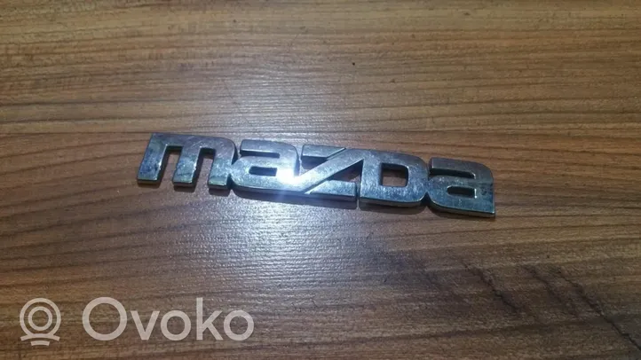 Mazda 323 Mostrina con logo/emblema della casa automobilistica 